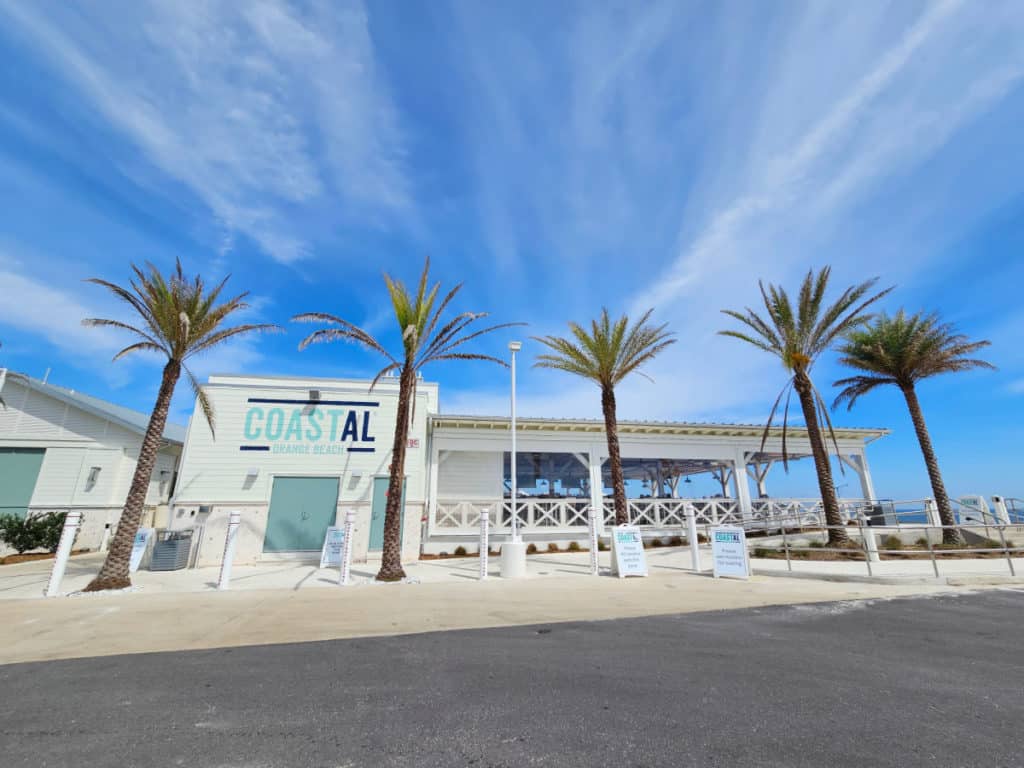 Coastal Orange Beach exterior with palm trees and blue skies