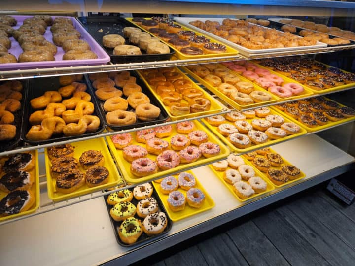Donut case with yellow trays of donuts at City Donut