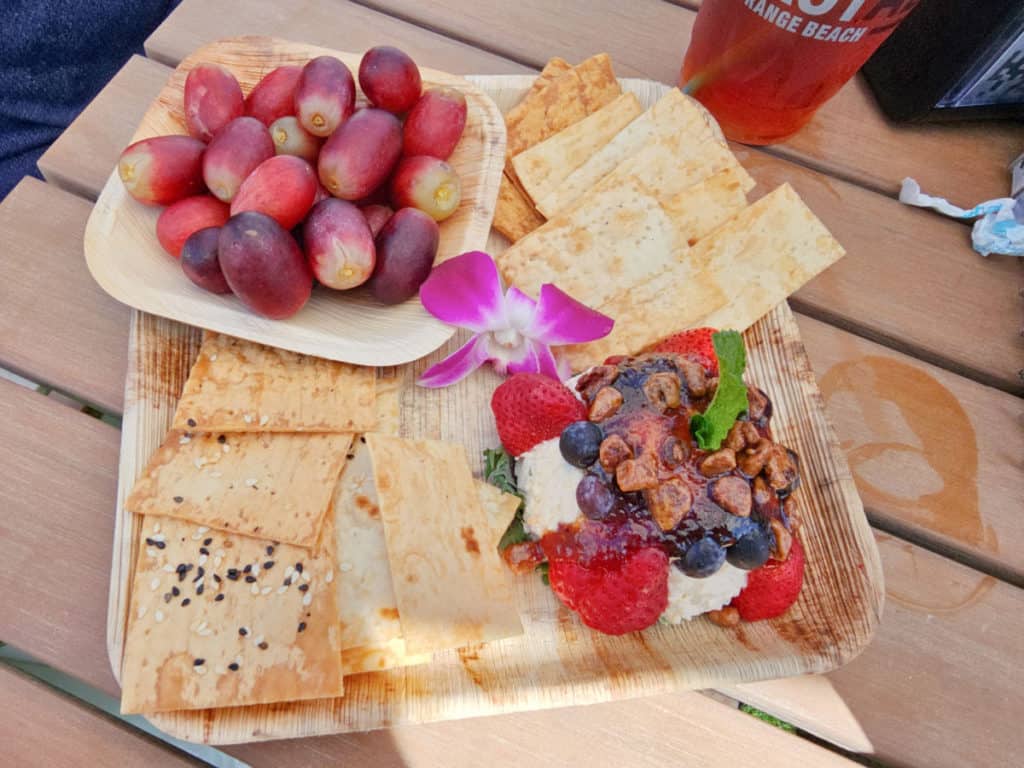 Pimento cheese appetizer with grapes, crackers, and an orchid