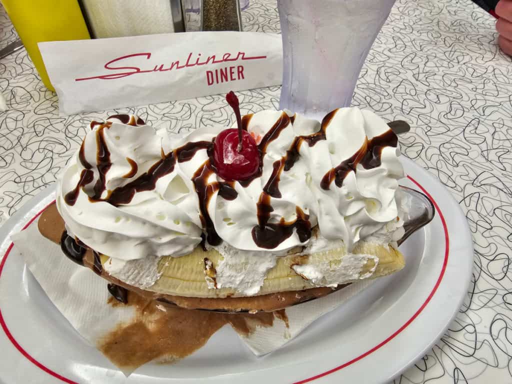 Banana split with a cherry on top on a white plate with Sunliner Diner napkins