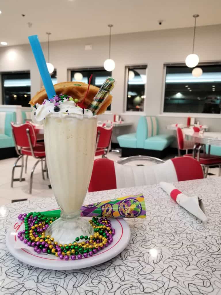 Milkshake with Mardi Gras decorations in a retro diner