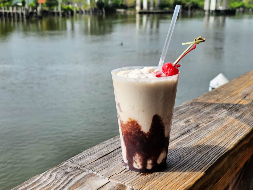 Bushwacker drink on a deck with water in the background