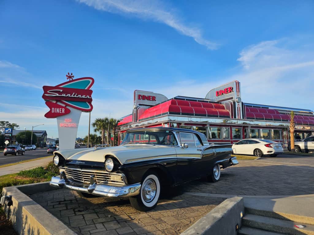 historic car parked in front of the Sunliner Diner Sign and restaurant
