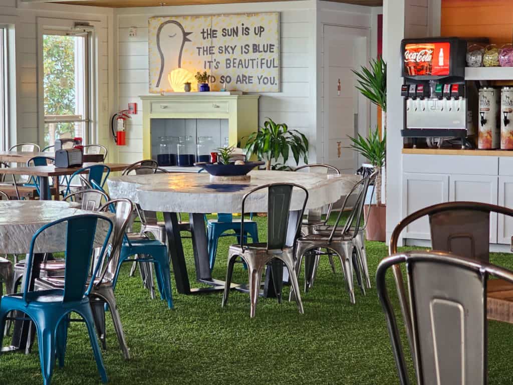 Indoor seating on green carpet with a coke machine in the background