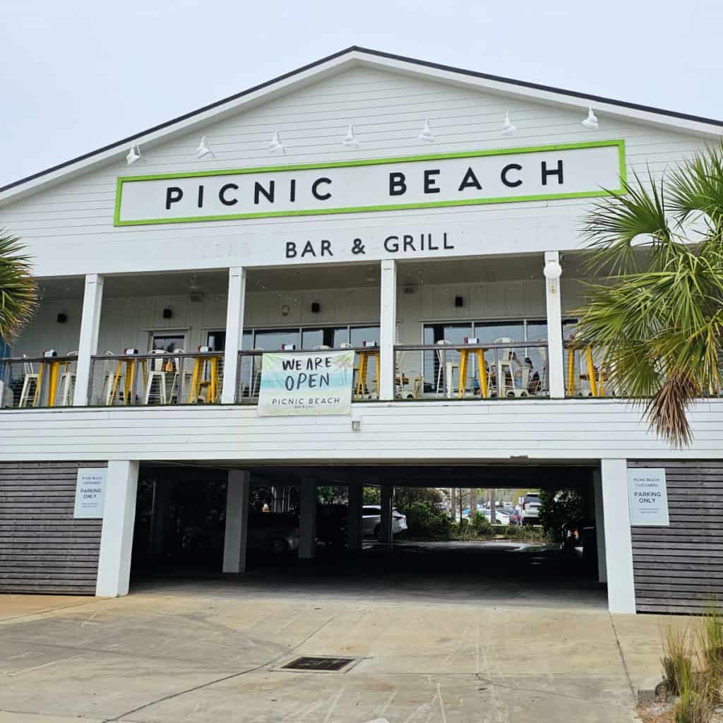 Picnic Beach Bar and Grill white building exterior with parking undernearth