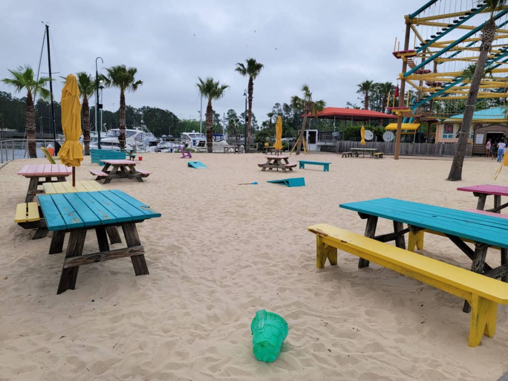 Sand play area with bright colored picnic areas and palm trees