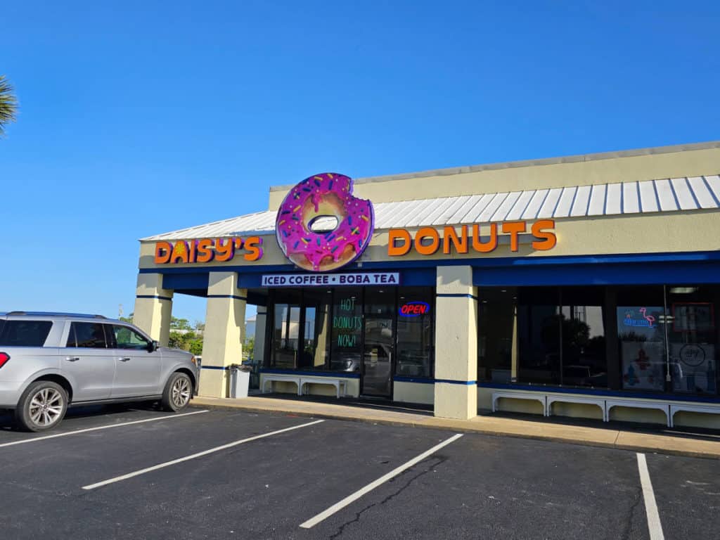 Exterior of Daisy's Donuts in Orange Beach with large pink doughnut