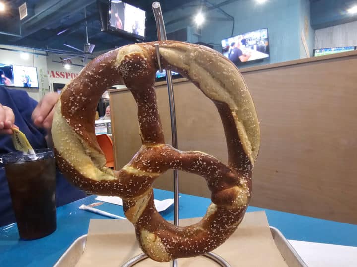 Giant pretzel hanging on a rack sitting on a plate
