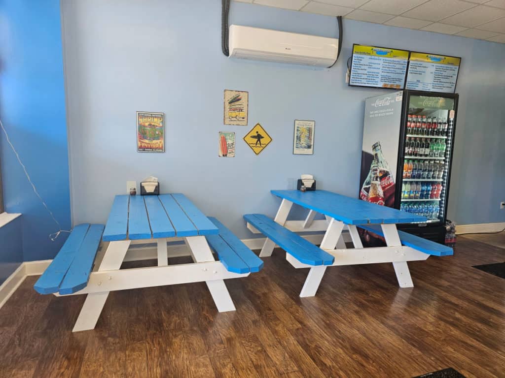 Blue picnic tables inside Surfside Pizza Gulf Shores