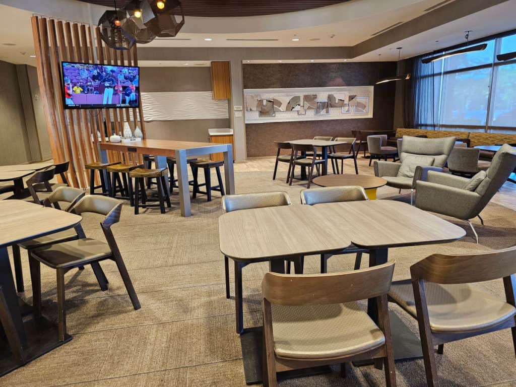 lobby area with tables and chairs and flat screen tv at the springhill suites at the wharf