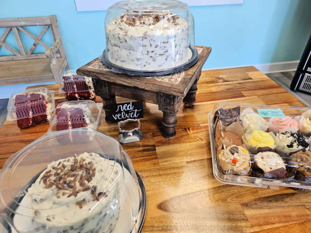 Red Velvet cakes and cake slices on a wooden table Deep South Cake Co
