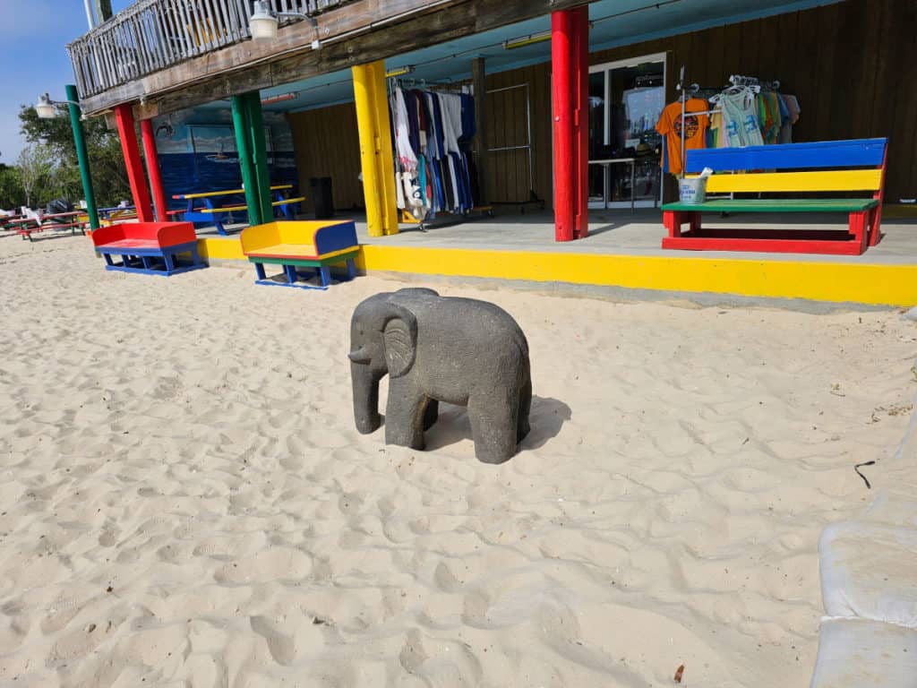Sandy beach area with elephant statue and colorful seating at Tacky Jacks Orange Beach