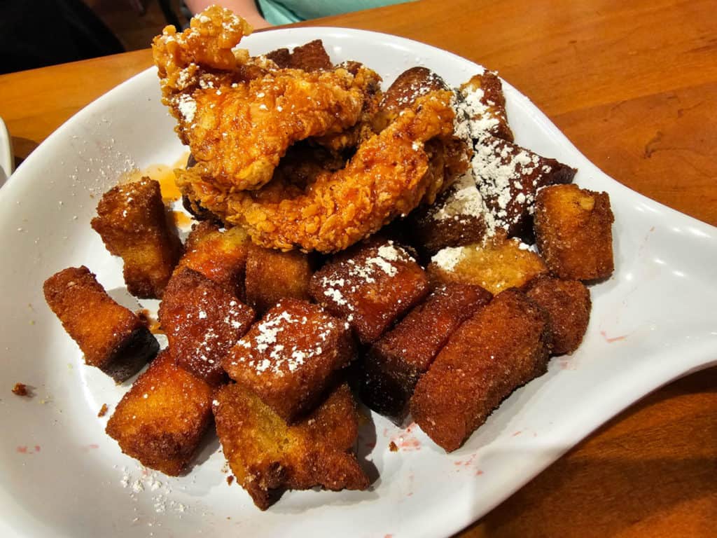 Chicken and french toast bites on a white plate