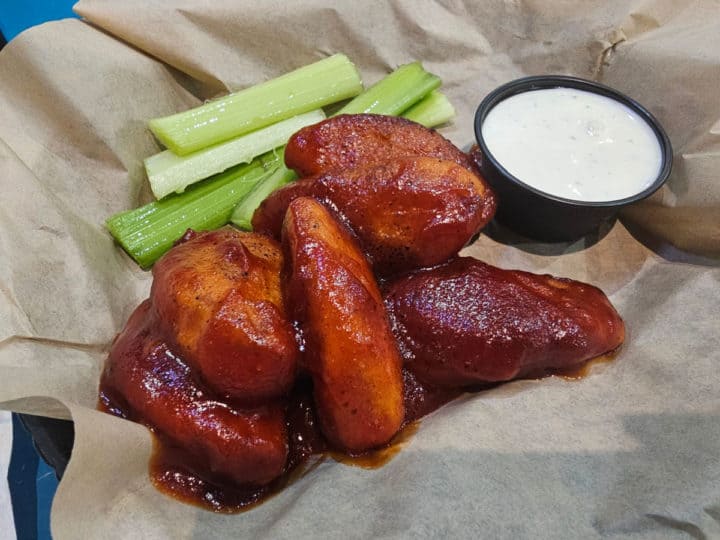 Vegetarian wings covered in sauce next to celery and ranch sauce