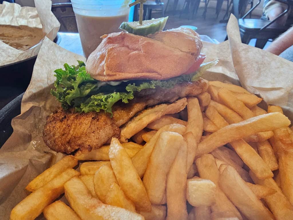 blackened snapper sandwich on a bun, next to French Fries at OSO Bear Point