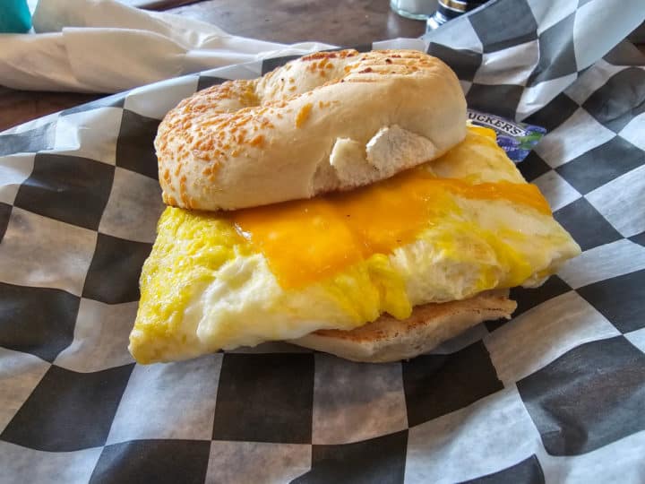 bagel breakfast sandwich with egg and cheese on a checkered paper