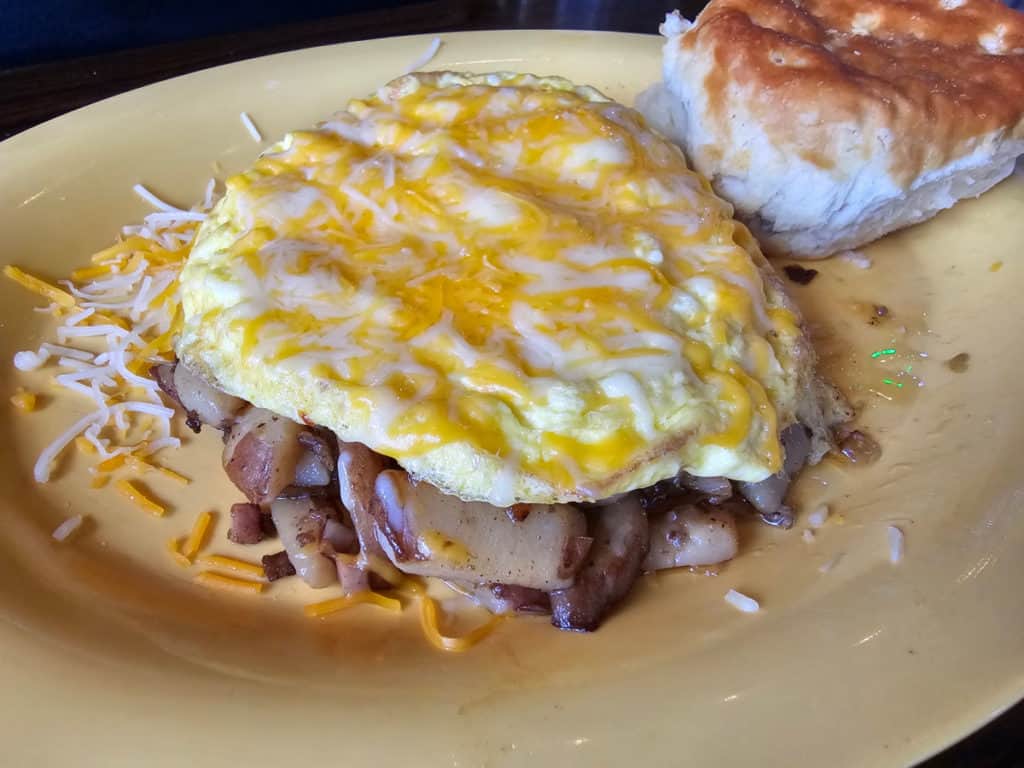 Farmers omelet next to a biscuit on a yellow plate at Tacky Jacks Gulf Shores