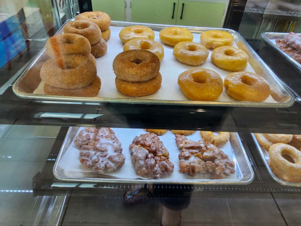 Glazed and cake donuts on parchment lined trays at Pete's Ice Cream and Donuts