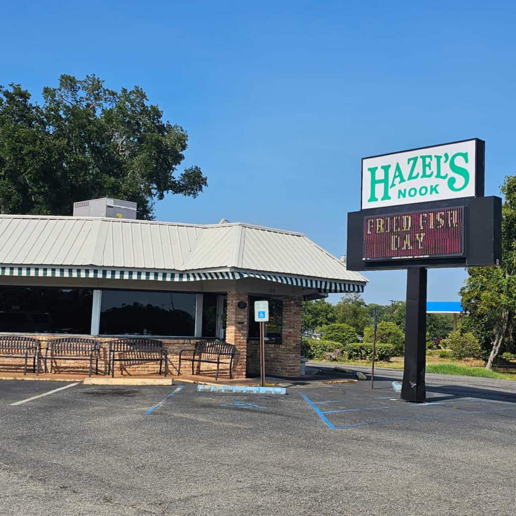 Hazel's Nook sign next to the restaurant with metal benches outside