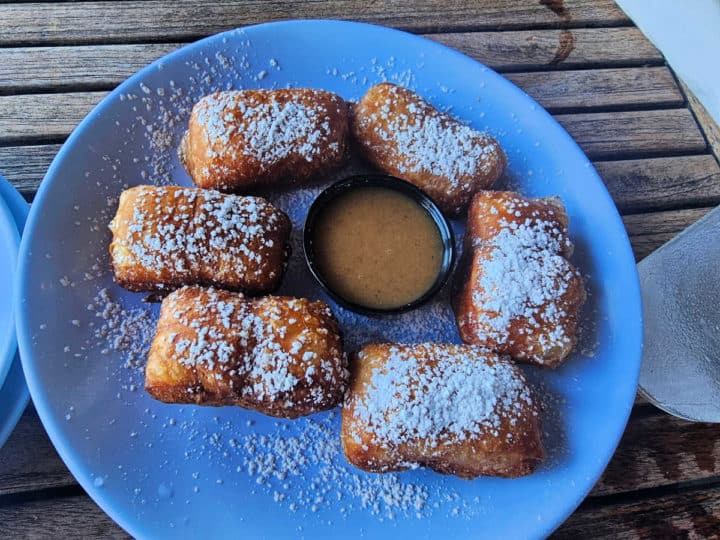 beignets with sauce on a blue plate