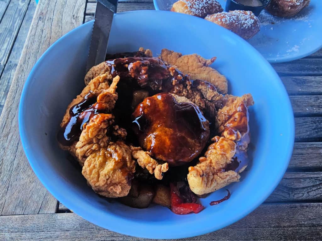 Fried chicken covered in syrup in a blue bowl