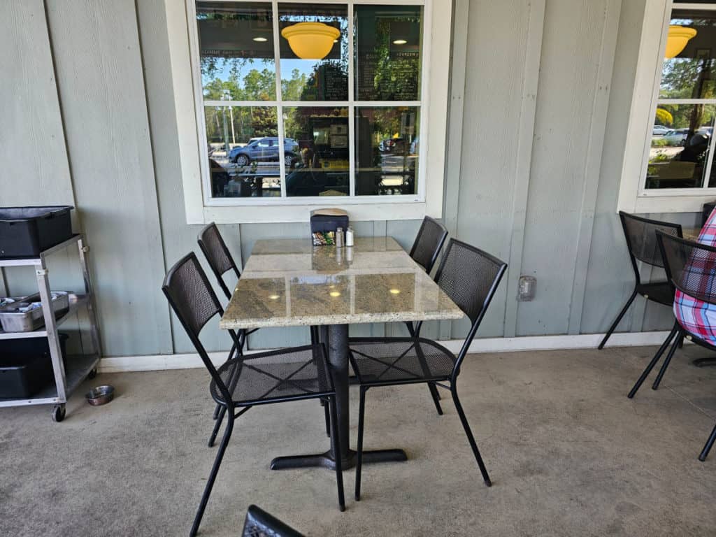 Outdoor seating with table and chairs at BuzzCatz coffee and sweets in Orange Beach
