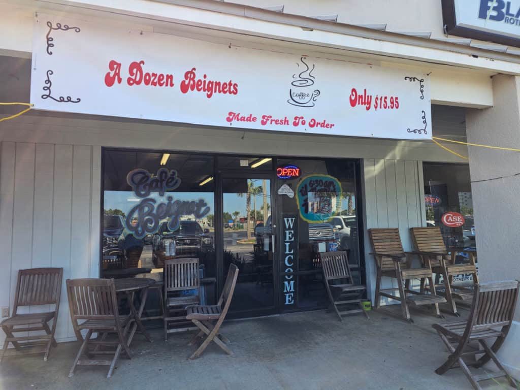 outdoor seating with wooden tables and chairs at Cafe Beignets Orange Beach