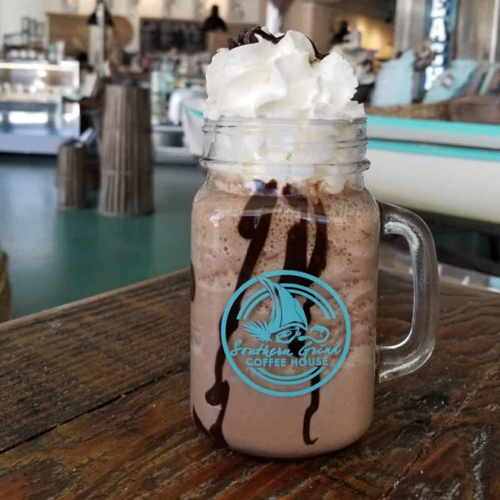 Southern Grind Coffee House glass filled with coffee and chocolate topped with whipped cream