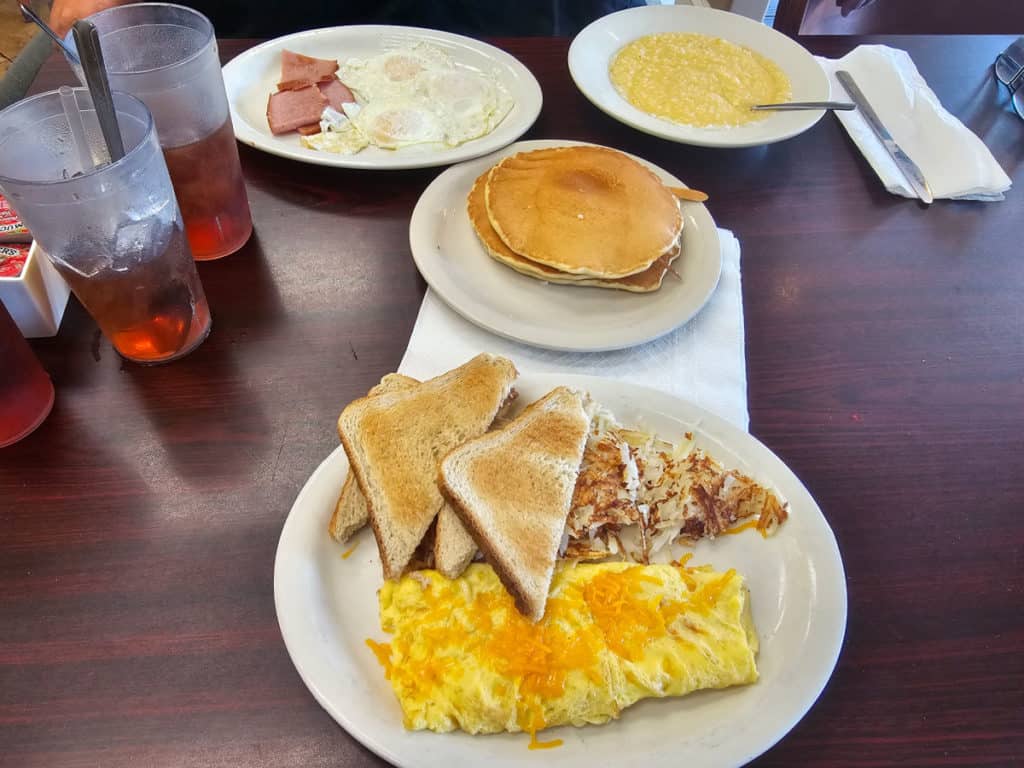 Breakfast at Gulf Shores Diner with pancakes, a cheese omelet, and toast, cheese grits