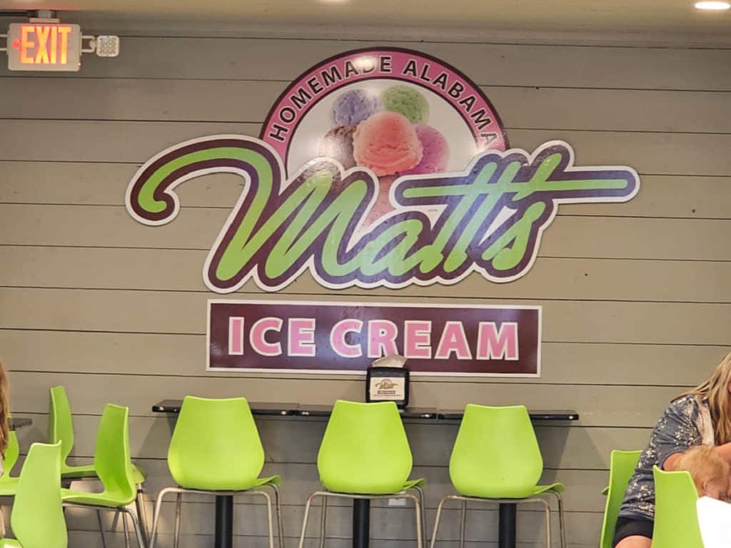 Green plastic chairs under a Matt's Ice Cream sign