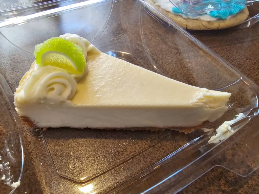 Slice of key lime cheesecake in a plastic container