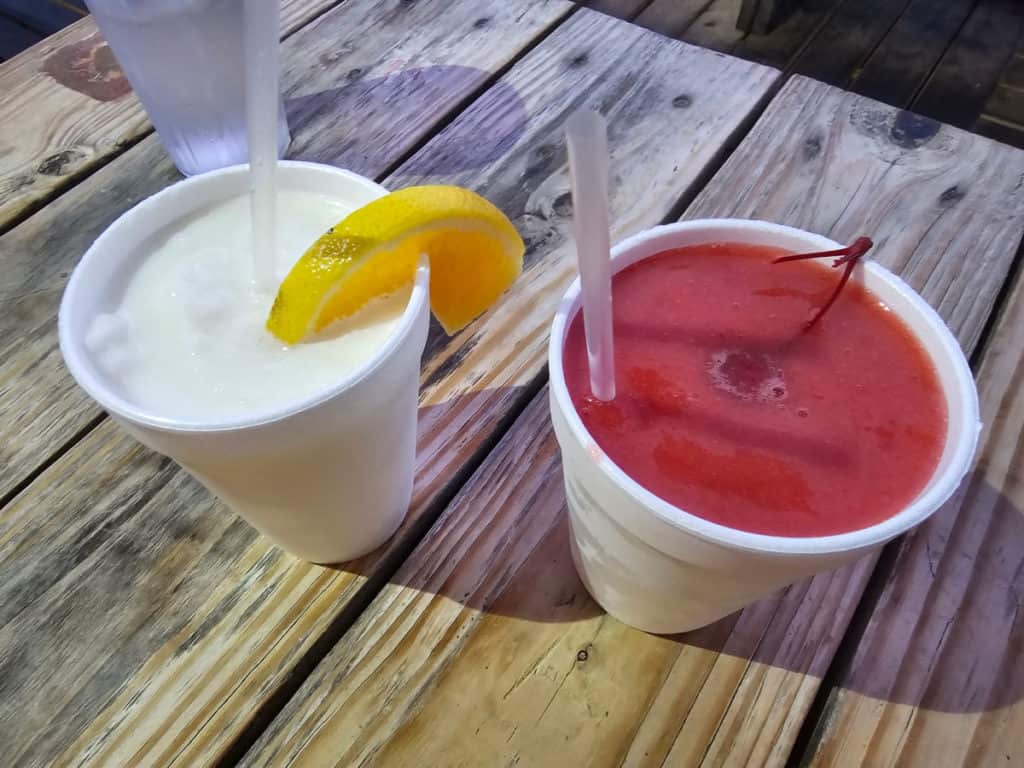 Key Lime Colada and Strawberry Daiquiri in white cups on a picnic table at Pink Pony Pub