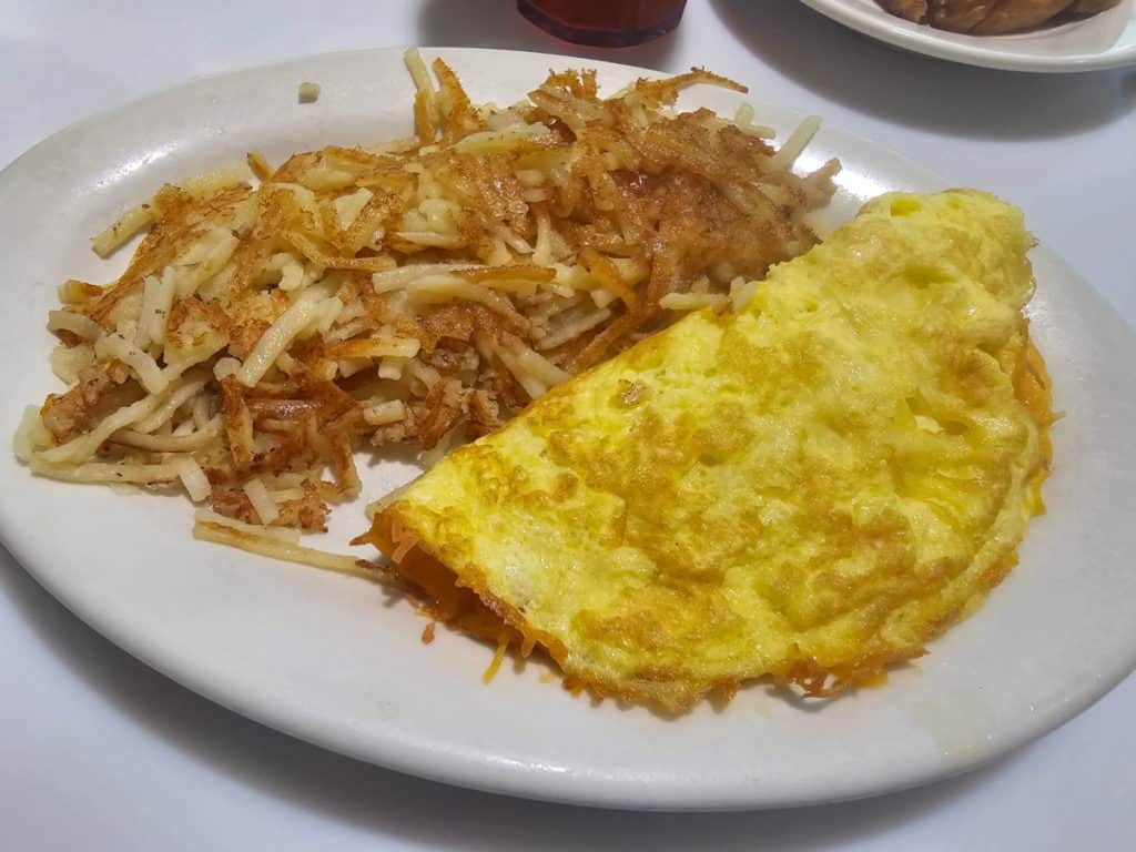 cheese omelet and hashbrowns on a white plate