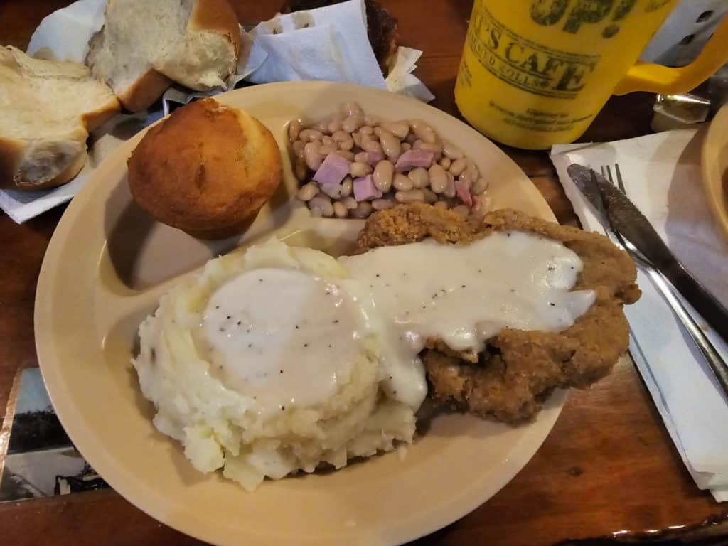 https://gulfcoastjourneys.com/wp-content/uploads/2023/09/Chicken-Fried-Steak-with-mashed-potatoes-and-gravy-white-beans-and-corn-bread-Lamberts-Cafe-Foley-Alabama-1024x768.jpg