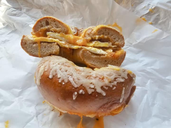 Egg and cheese on an asiago bagel sitting on white paper 