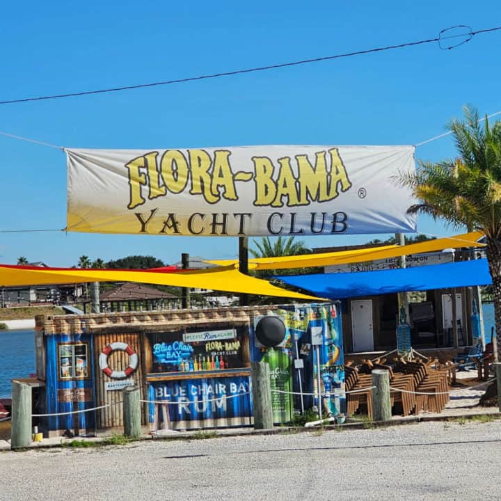 Flora Bama yacht club sign over a blue chair rum bar sign 
