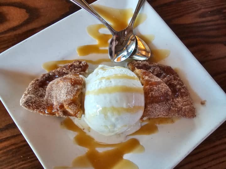 Fried Apple Pie with vanilla ice cream and caramel sauce on a white plate at Cobalt