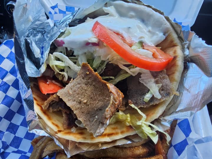 Gyro wrapped in foil over a container of fries Efes Greek Kitchen