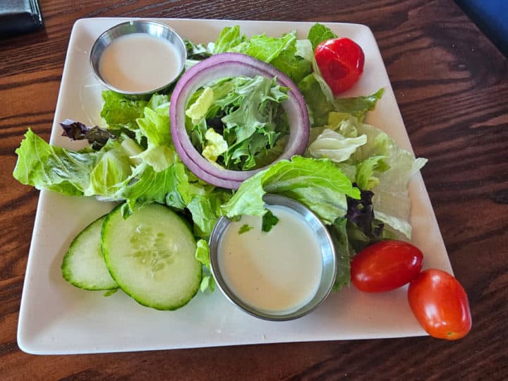 House salad on a white plate with ranch dressing at Cobalt
