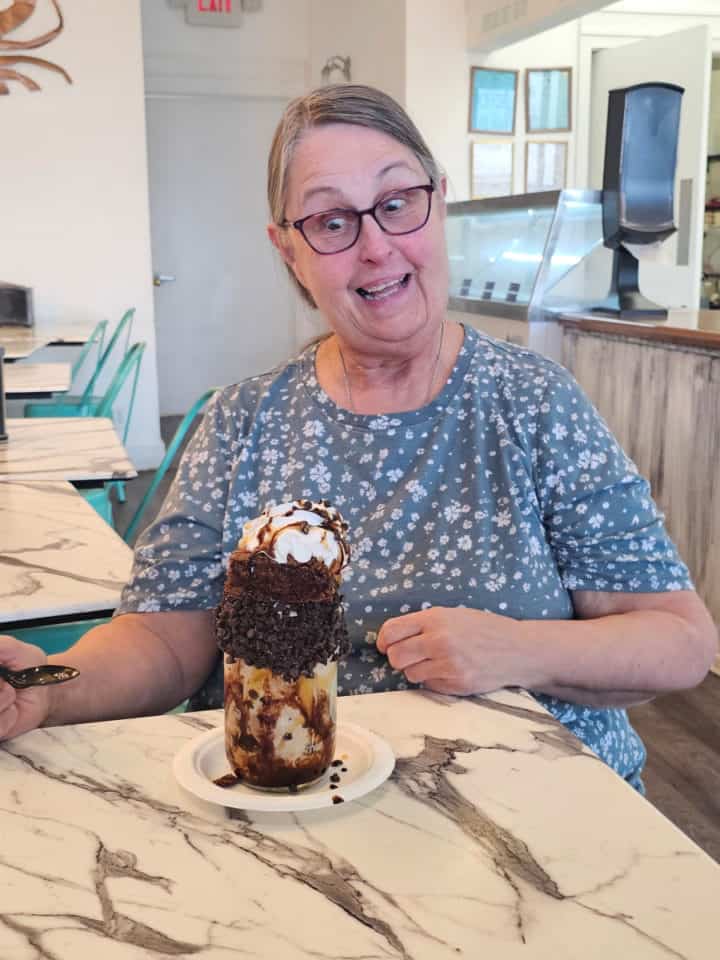 Woman with surprised face looking at a mason jar sundae