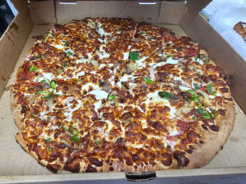 Large supreme pizza in a cricos pizza box