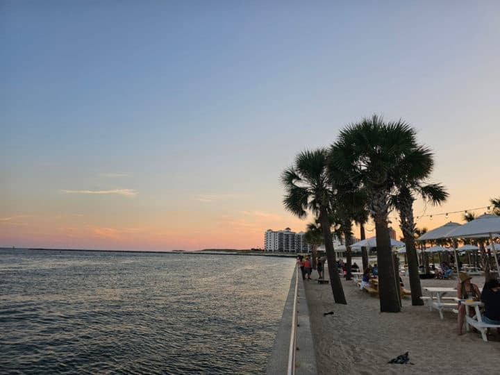 Sunset over the Gulf and Palm Trees with people eating 