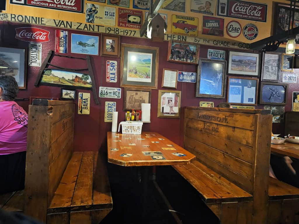 wooden bench booth seating in Lamberts Cafe Foley with photos all over the wall behind the booth