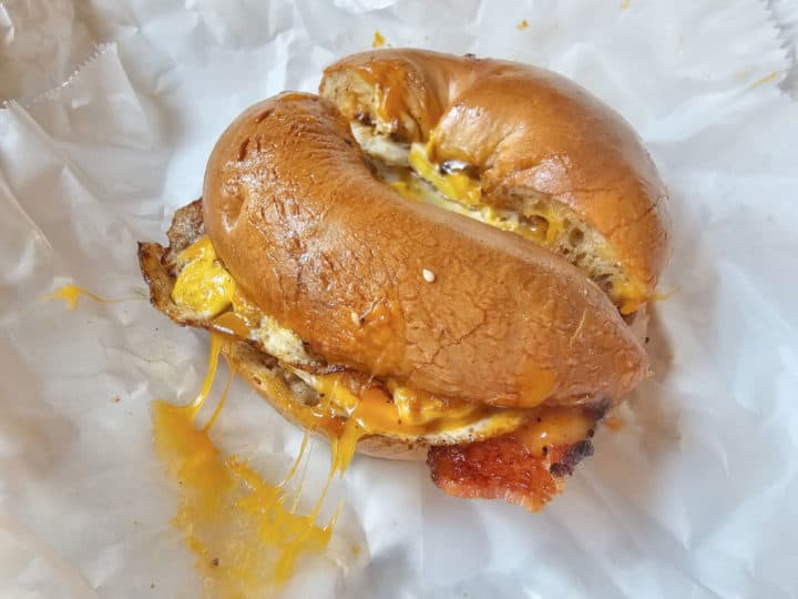 plain bagel with egg, cheese, and bacon on a white wrapper