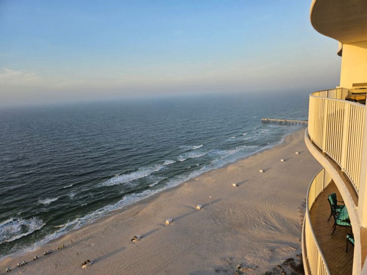 balcony view with the Gulf of Mexico, white sand beaches, and sunrise clouds