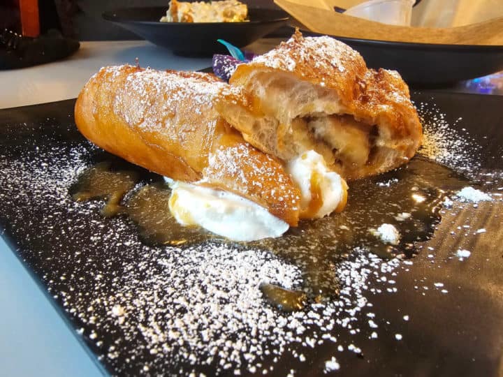 banana stuffed French Toast on a dark plate with powdered sugar