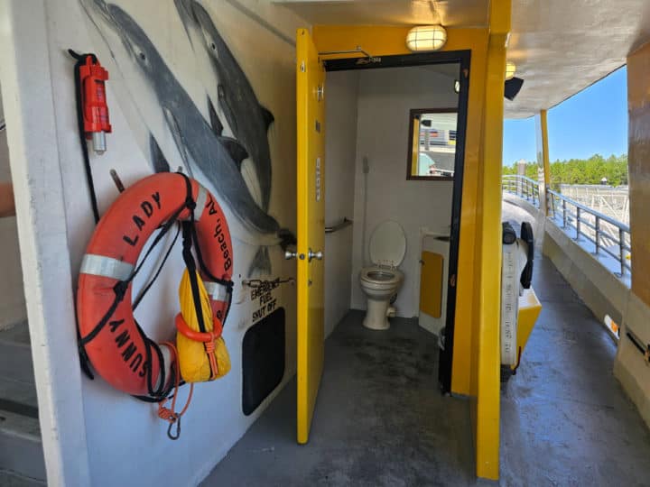 boat bathroom next to a life ring and walkway