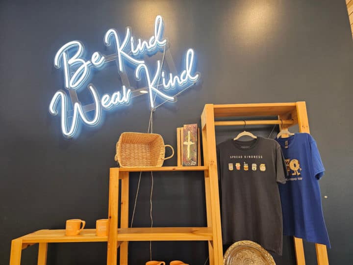 Be Kind Wear Kind merchandise with t-shirt stand