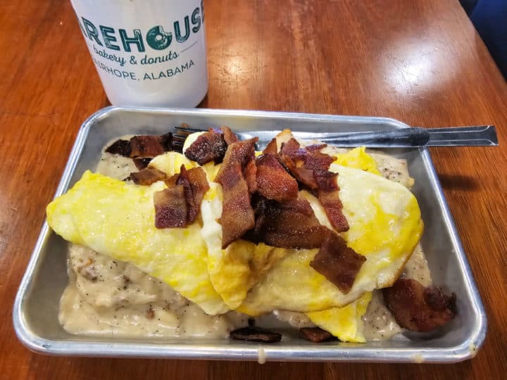 biscuits and gravy topped with scrambled eggs and crumbled bacon