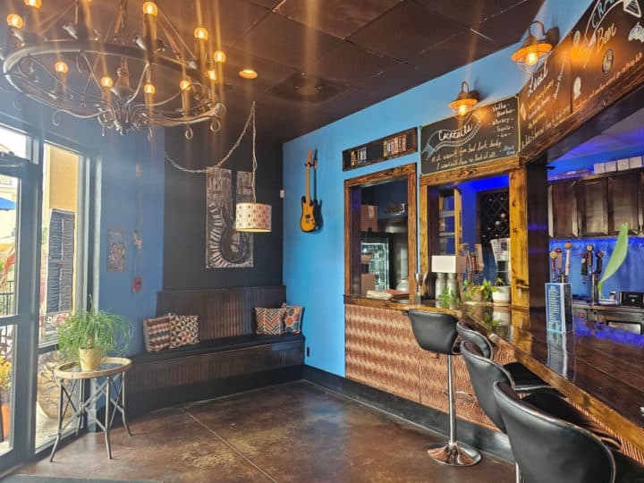 Entrance to Bleus Burgers with blue walls, a chandelier and seating at the bar